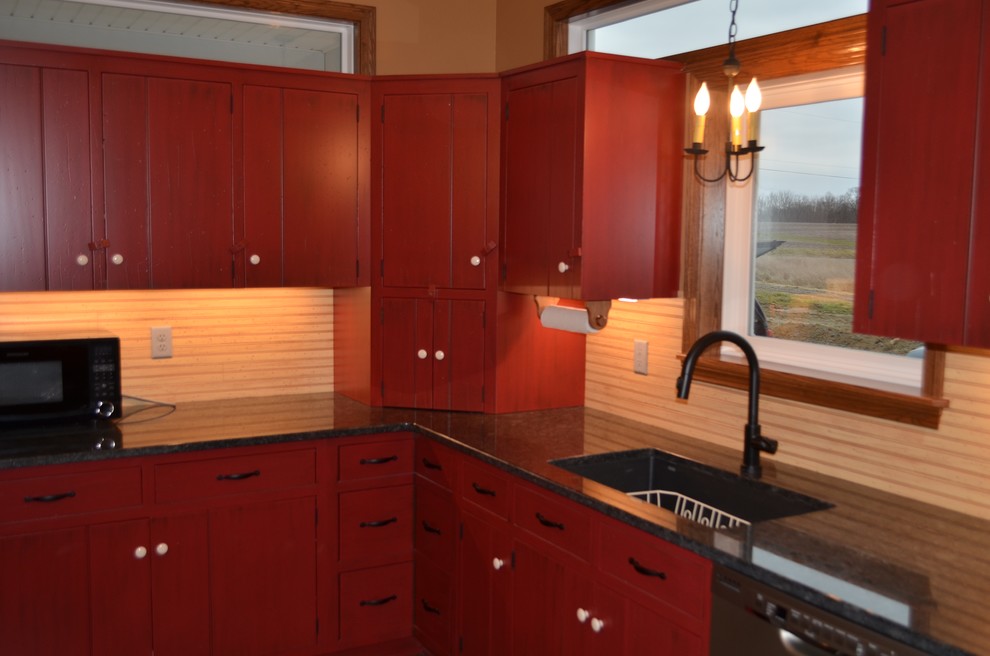 Example of a large transitional l-shaped dark wood floor and brown floor eat-in kitchen design with an undermount sink, flat-panel cabinets, red cabinets, granite countertops, beige backsplash, stainless steel appliances and an island