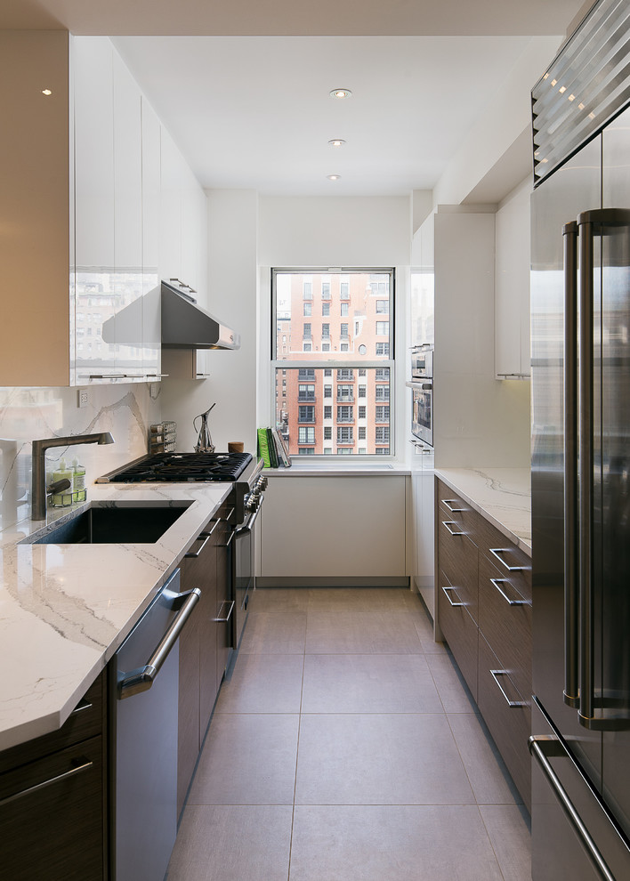 This is an example of a mid-sized contemporary u-shaped open plan kitchen in New York with an undermount sink, flat-panel cabinets, dark wood cabinets, quartz benchtops, white splashback, stone slab splashback, stainless steel appliances, ceramic floors, multiple islands, grey floor and white benchtop.