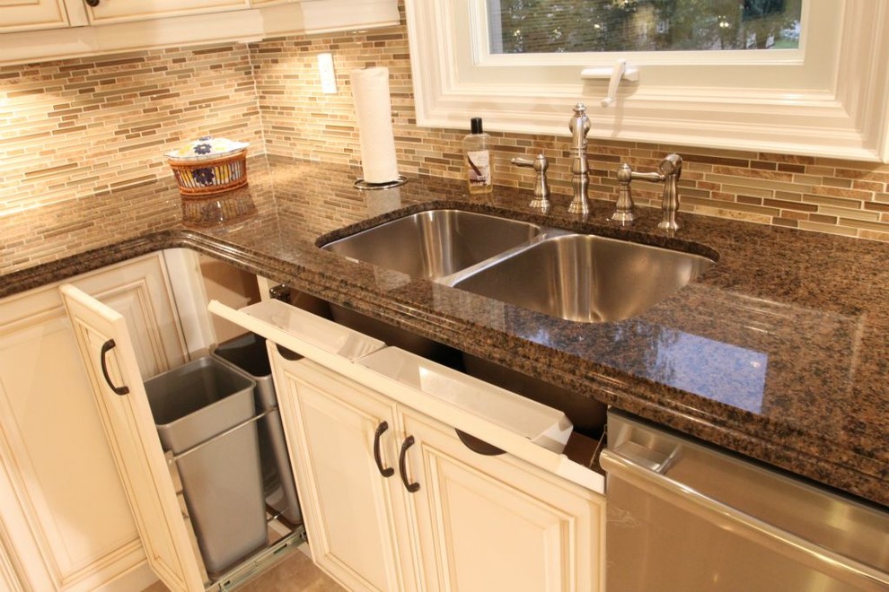 Photo of a mid-sized traditional u-shaped eat-in kitchen in Toronto with a double-bowl sink, quartz benchtops, brown splashback, ceramic splashback, stainless steel appliances, porcelain floors, no island, yellow floor, white cabinets and raised-panel cabinets.