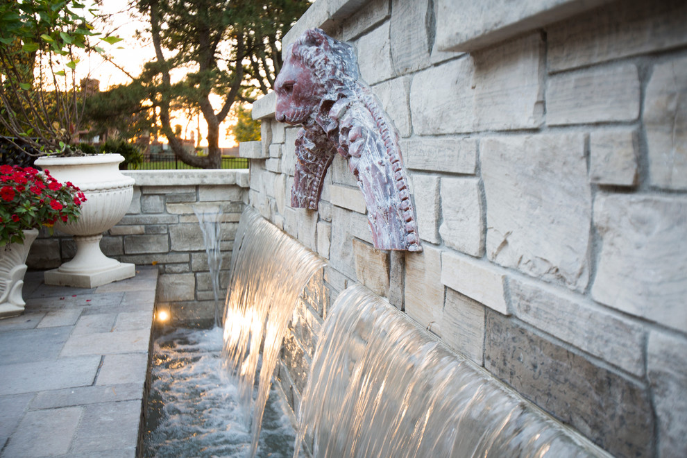 Design ideas for a transitional backyard stone water fountain landscape in Omaha.