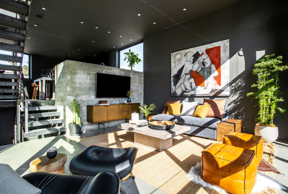 Идея дизайна: открытая гостиная комната среднего размера в стиле лофт с серыми стенами, бетонным полом, телевизором на стене и серым полом без камина