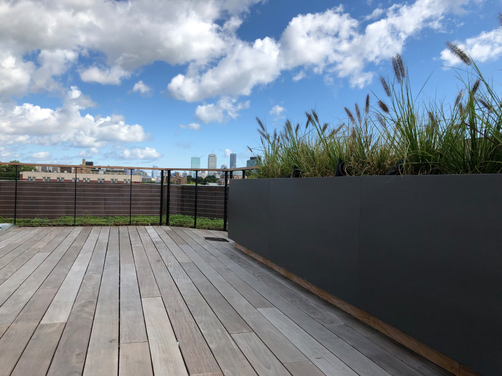 This is an example of a large contemporary roof rooftop wire cable railing terrace in Boston with a potted garden and no cover.