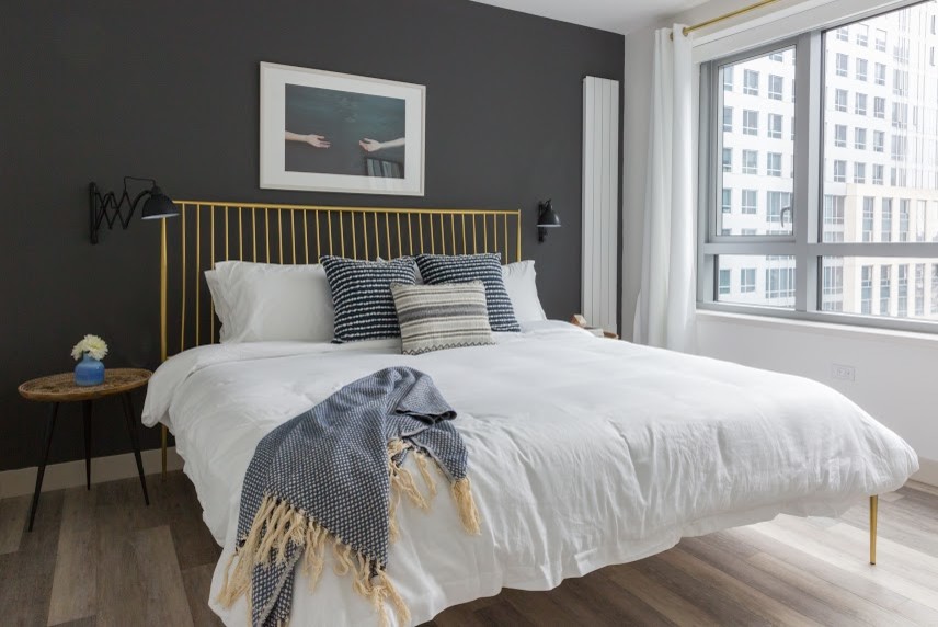 Design ideas for a small eclectic master bedroom in San Francisco with black walls, light hardwood floors and beige floor.