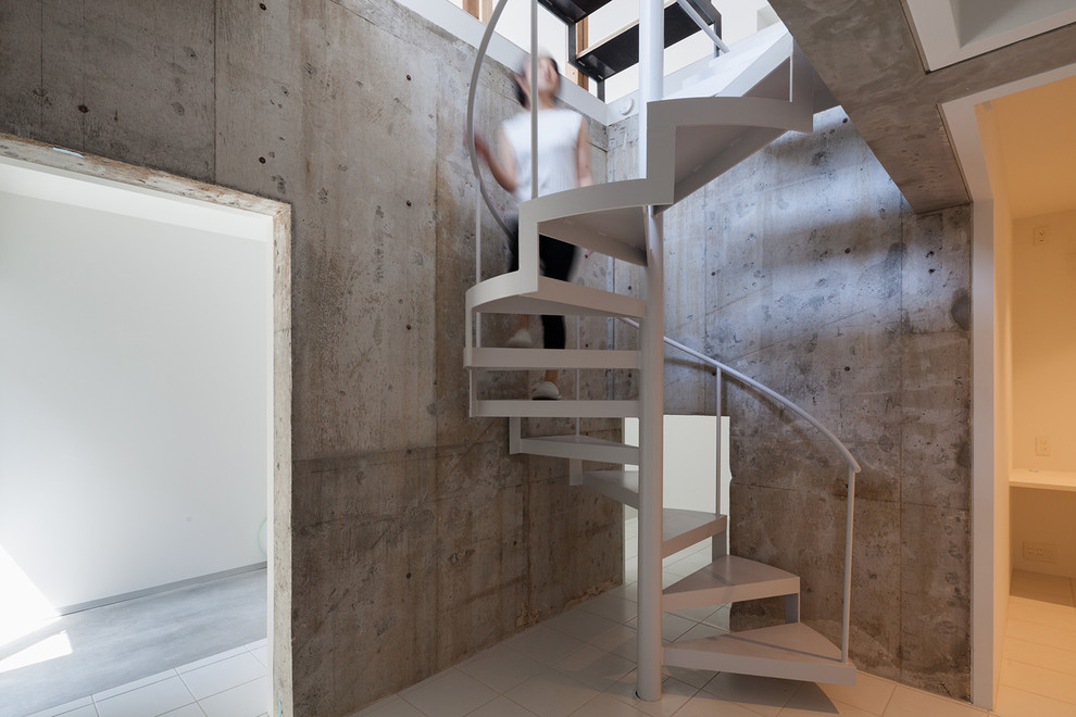 This is an example of a modern tile staircase in Tokyo with open risers and metal railing.