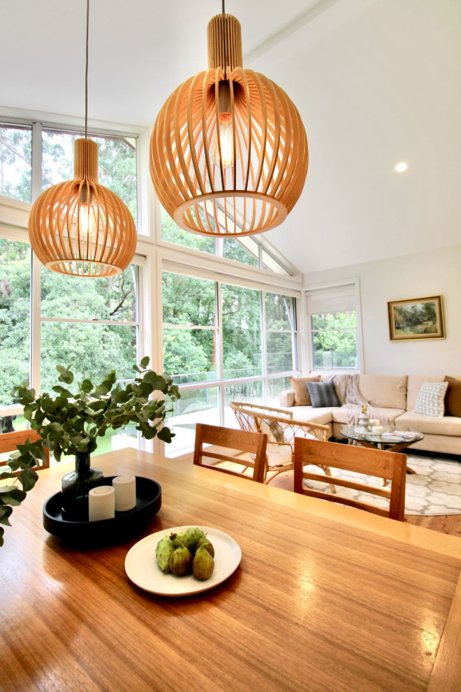 Eclectic open plan kitchen in Sydney with light hardwood floors and vaulted.