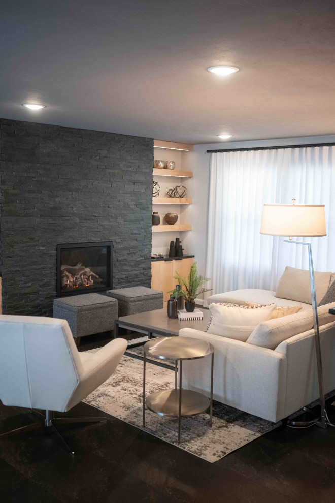 Photo of a large midcentury open plan living room in Other with grey walls, vinyl flooring, a standard fireplace, a stone fireplace surround and black floors.