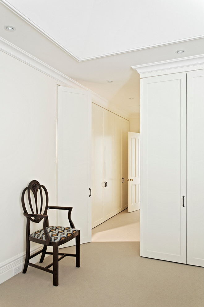Mid-sized transitional gender-neutral built-in wardrobe in Sydney with recessed-panel cabinets, white cabinets and carpet.