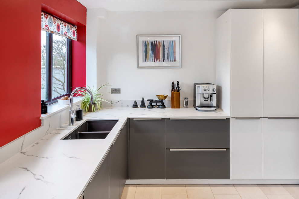 Mid-sized contemporary l-shaped kitchen in Other with a drop-in sink, red splashback, glass sheet splashback and a peninsula.