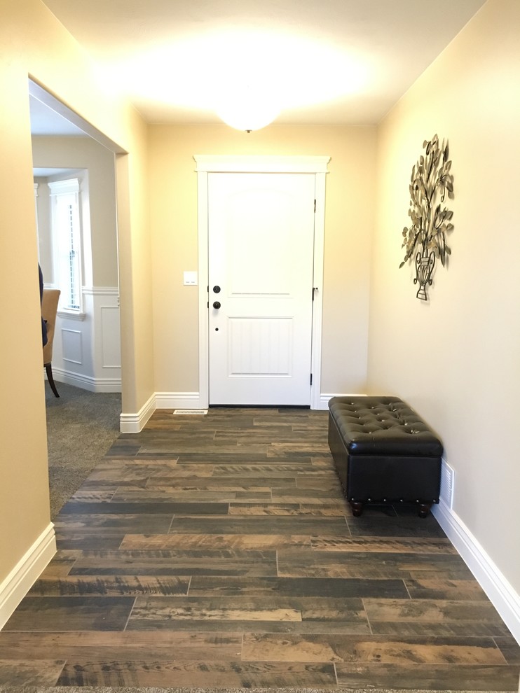 Example of a mid-sized transitional porcelain tile foyer design with beige walls and a white front door