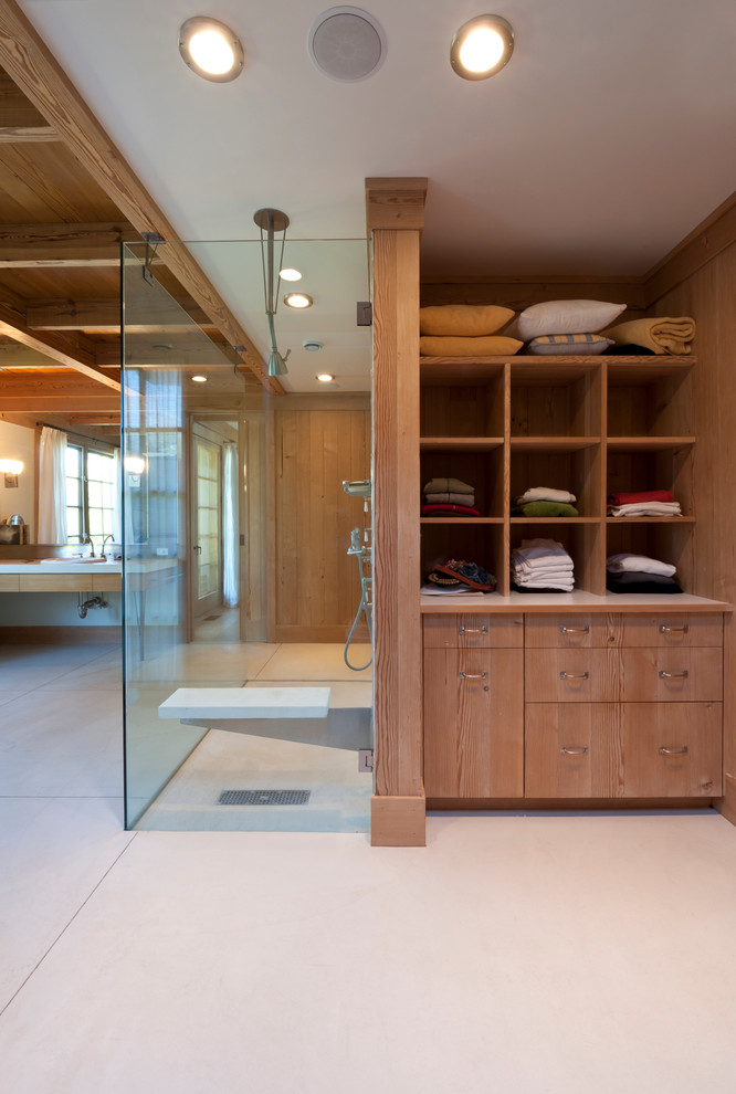 This is an example of a large country master bathroom in New York with open cabinets, medium wood cabinets, a curbless shower, brown walls, concrete floors, a drop-in sink and beige floor.
