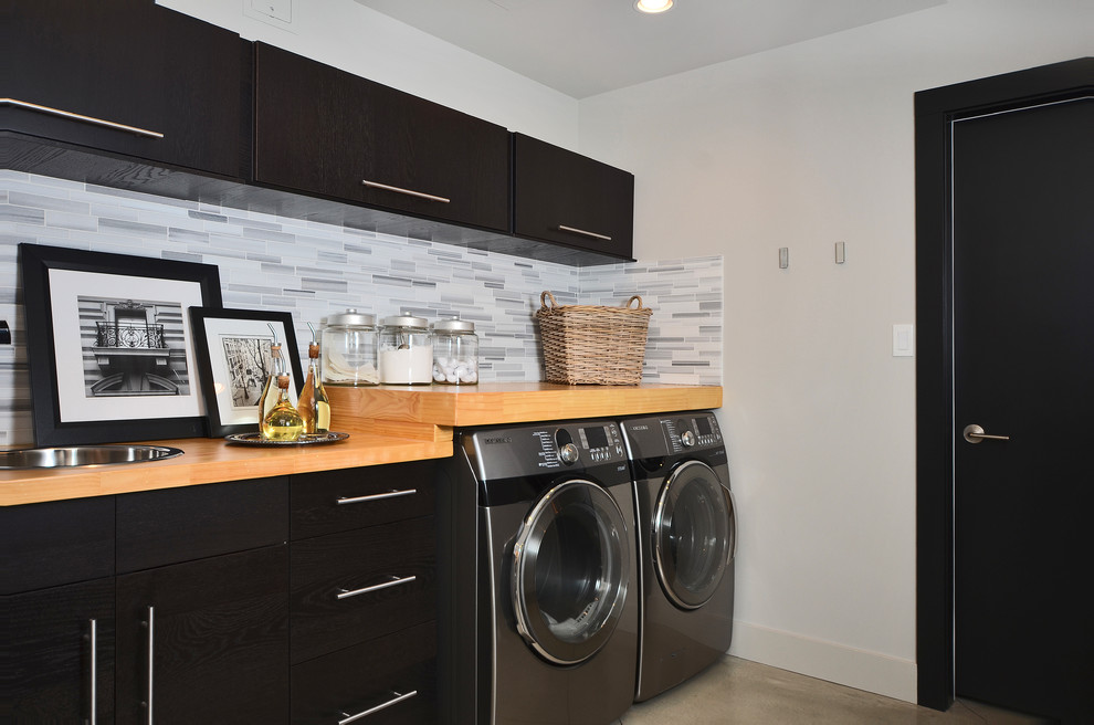 Contemporary laundry room in Vancouver with dark wood cabinets.