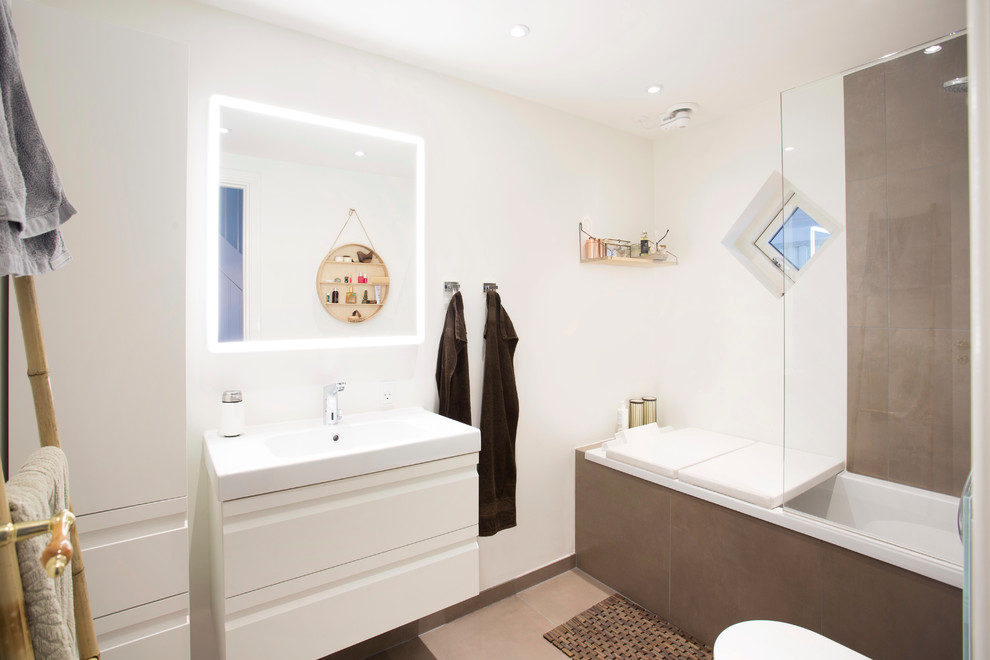 Inspiration for a mid-sized contemporary master bathroom in Copenhagen with flat-panel cabinets, white cabinets, a drop-in tub, stone tile, white walls, porcelain floors, an integrated sink and an open shower.