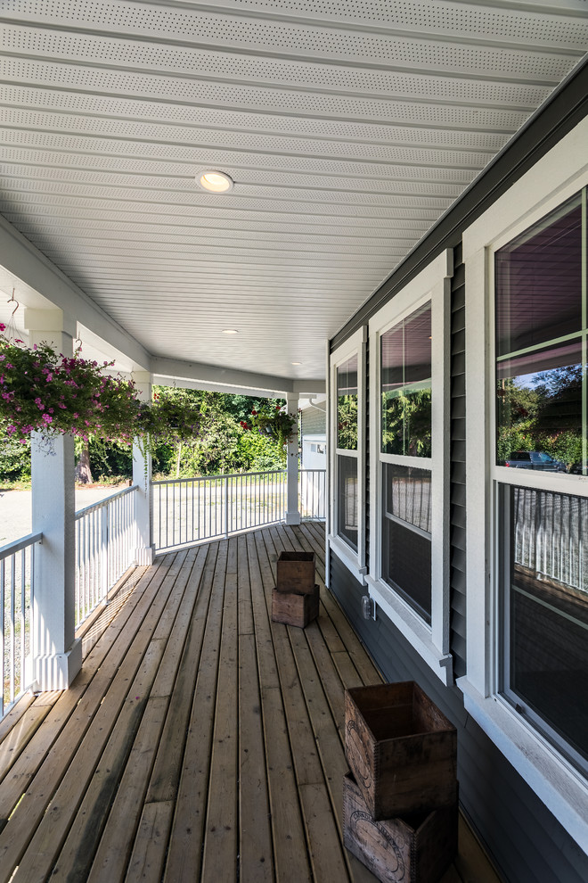 Photo of a mid-sized traditional front yard verandah in Vancouver with decking and a roof extension.