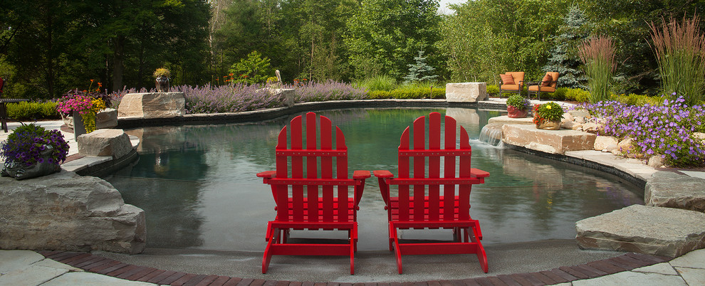 Inspiration for a transitional backyard concrete paver and custom-shaped natural pool fountain remodel in Grand Rapids