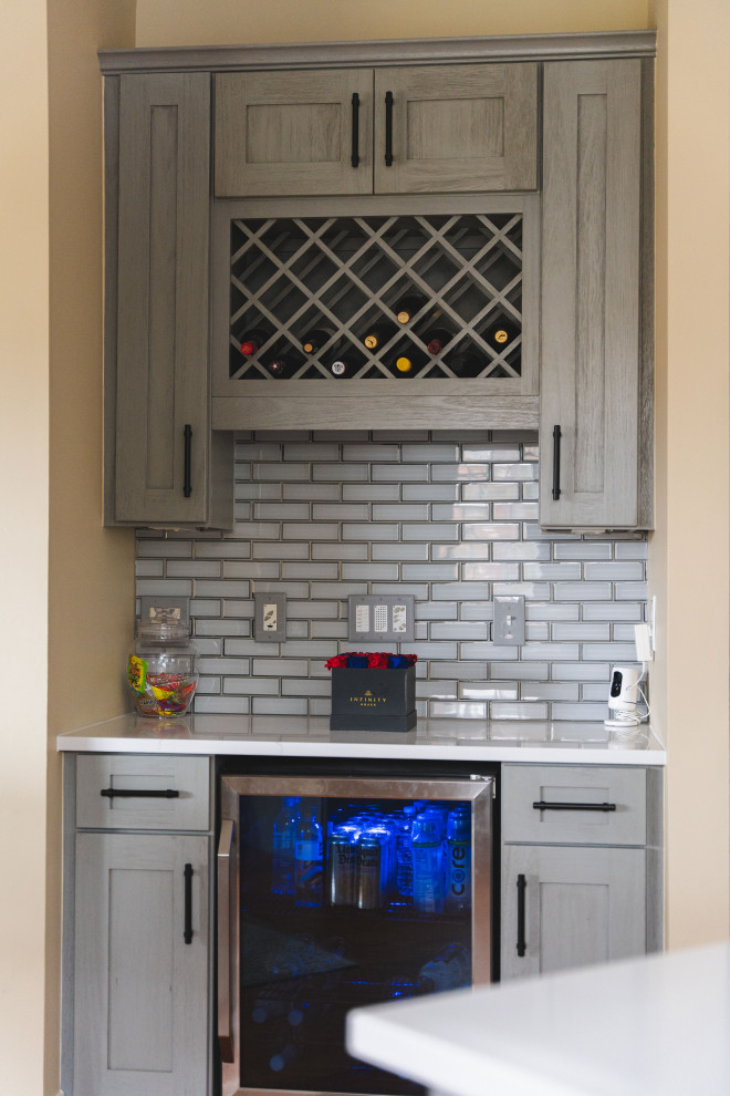 Inspiration for a large transitional u-shaped medium tone wood floor and brown floor eat-in kitchen remodel with a farmhouse sink, shaker cabinets, gray cabinets, quartz countertops, gray backsplash, glass tile backsplash, stainless steel appliances, an island and white countertops