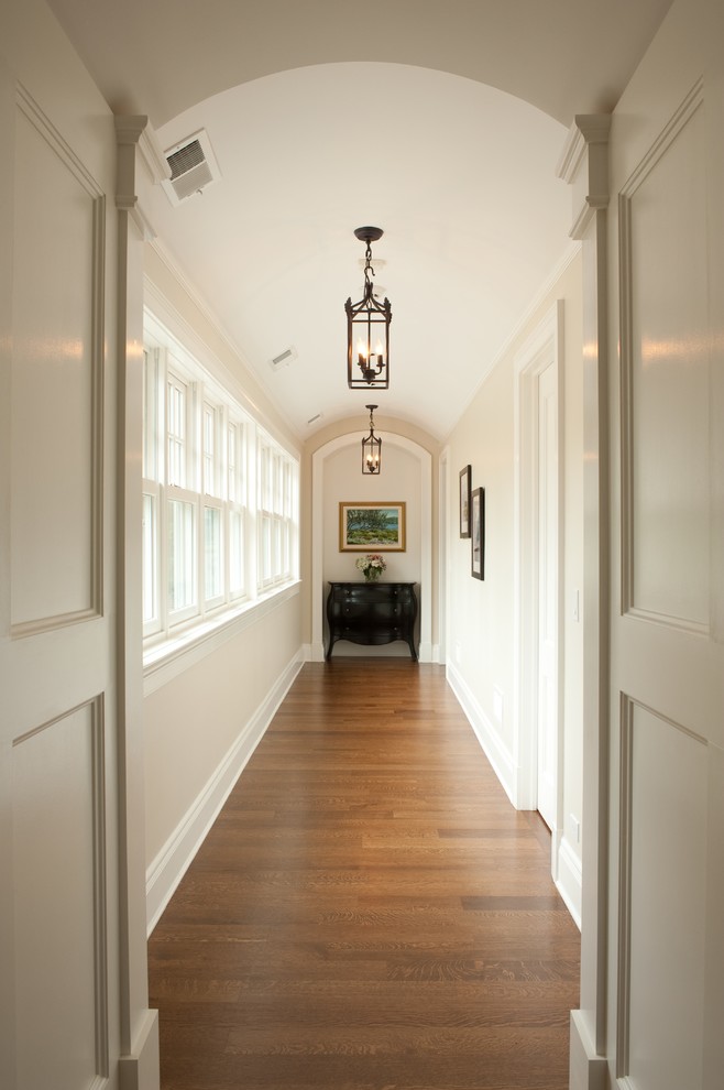 Photo of a mid-sized arts and crafts hallway in Chicago with beige walls and medium hardwood floors.