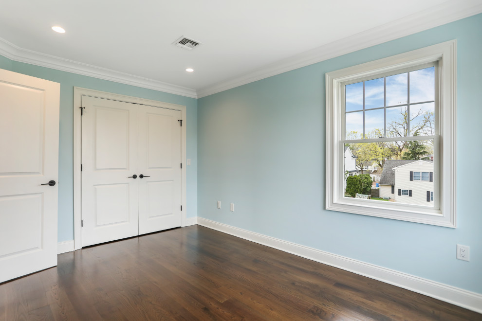 Idéer för ett mellanstort modernt gästrum, med blå väggar, mellanmörkt trägolv och brunt golv