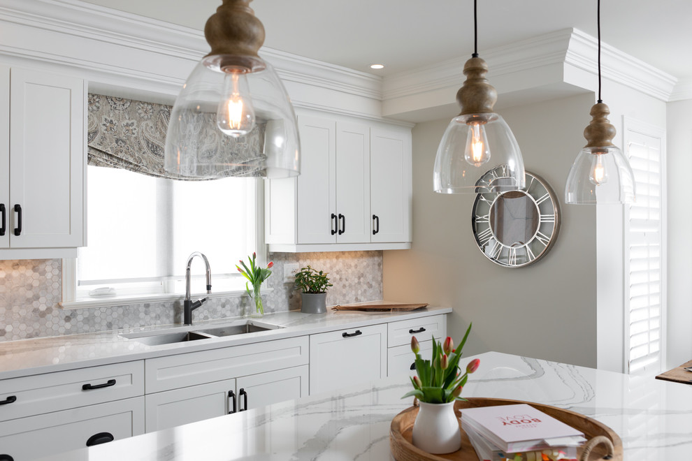 Inspiration for a transitional dark wood floor and brown floor kitchen remodel with white cabinets, quartz countertops, paneled appliances, an island and white countertops