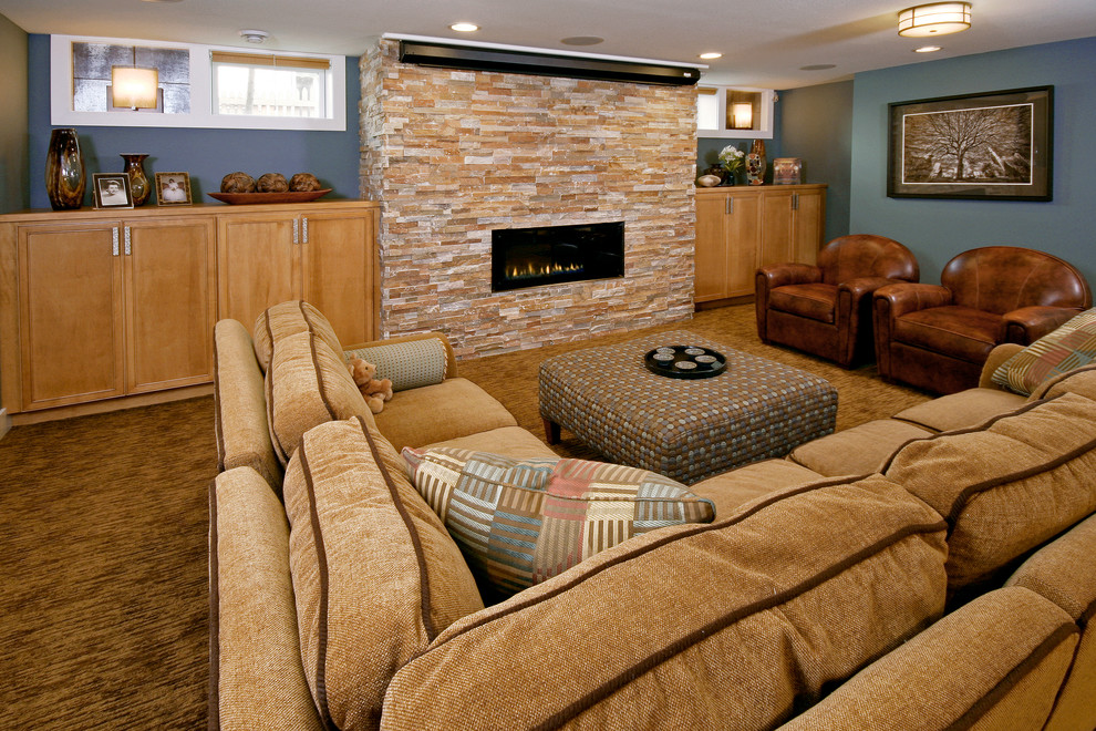 This is an example of a transitional fully buried basement in Milwaukee with blue walls, carpet, a ribbon fireplace and a stone fireplace surround.