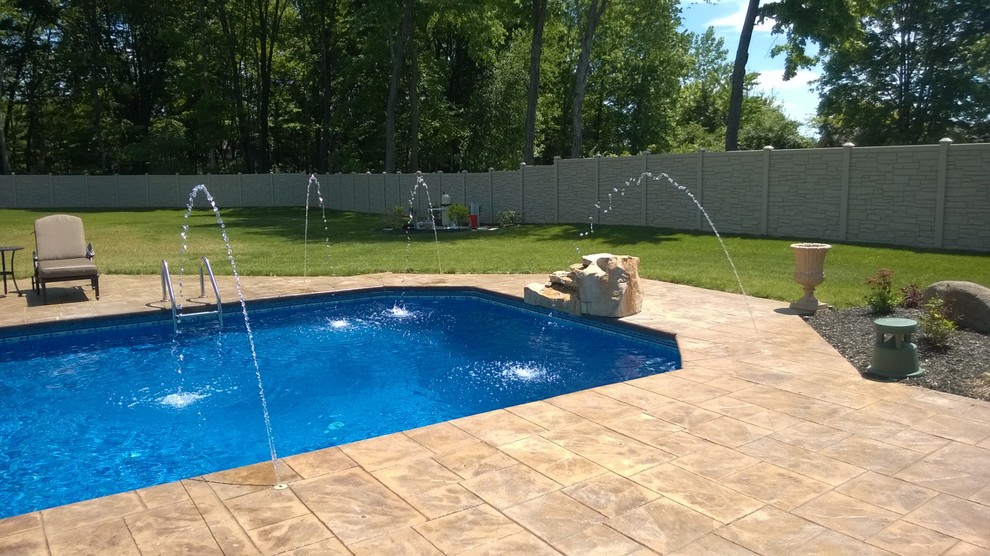 Example of a mid-sized minimalist backyard stamped concrete and rectangular natural pool fountain design in Chicago