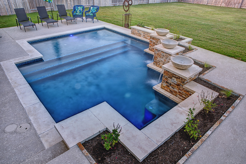 Photo of a mid-sized traditional backyard custom-shaped pool in Austin with a water feature and concrete slab.