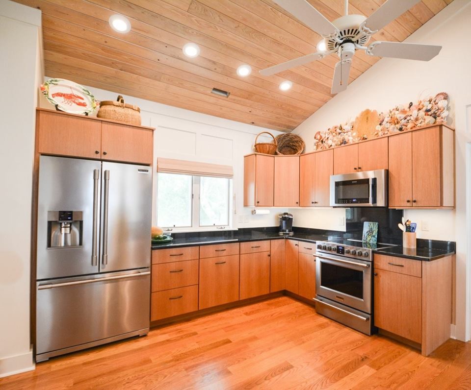 Inspiration for a mid-sized transitional l-shaped medium tone wood floor and brown floor open concept kitchen remodel with flat-panel cabinets, medium tone wood cabinets, quartz countertops, stainless steel appliances and no island
