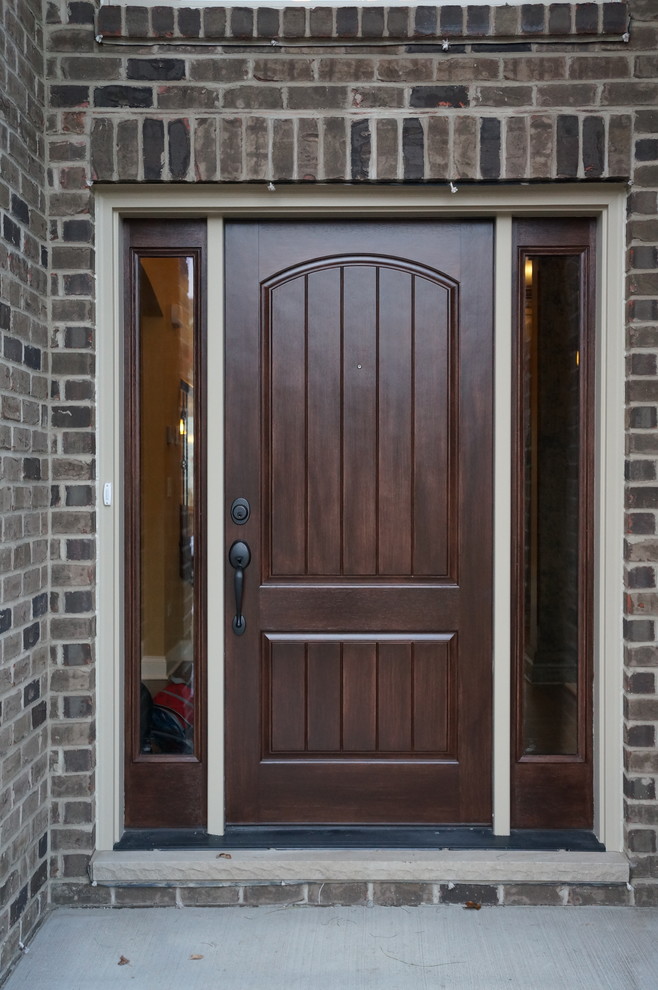 This is an example of a mid-sized traditional front door in Chicago with a single front door and a dark wood front door.