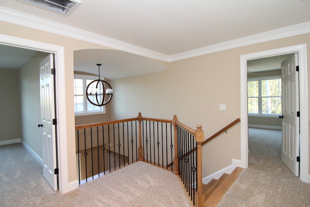 This is an example of a mid-sized transitional hallway in Raleigh with beige walls and carpet.