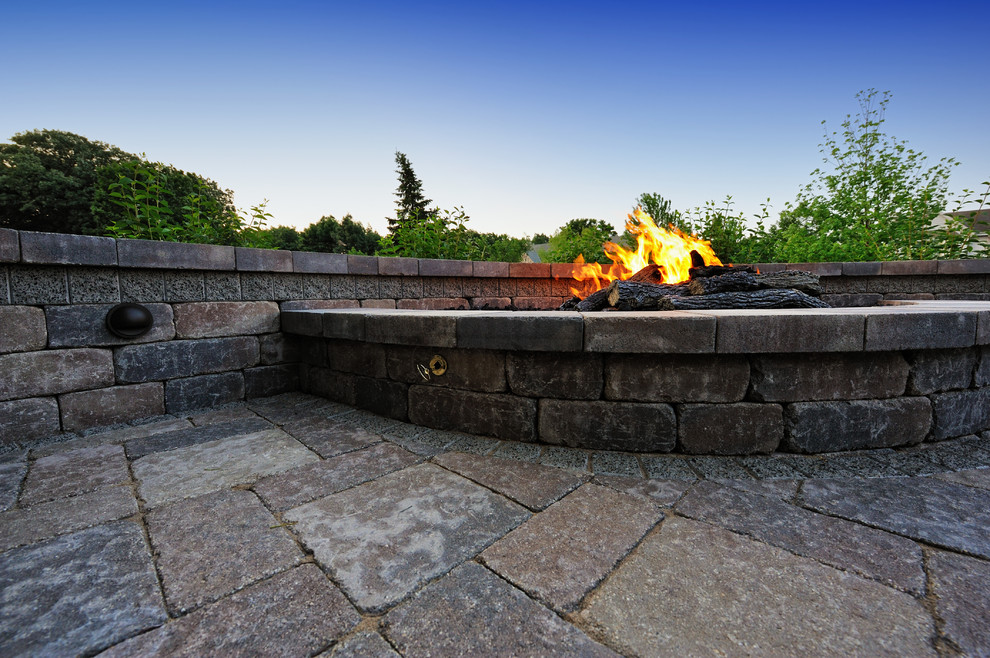 Inspiration for a mid-sized traditional backyard patio in Milwaukee with a fire feature, concrete pavers and no cover.