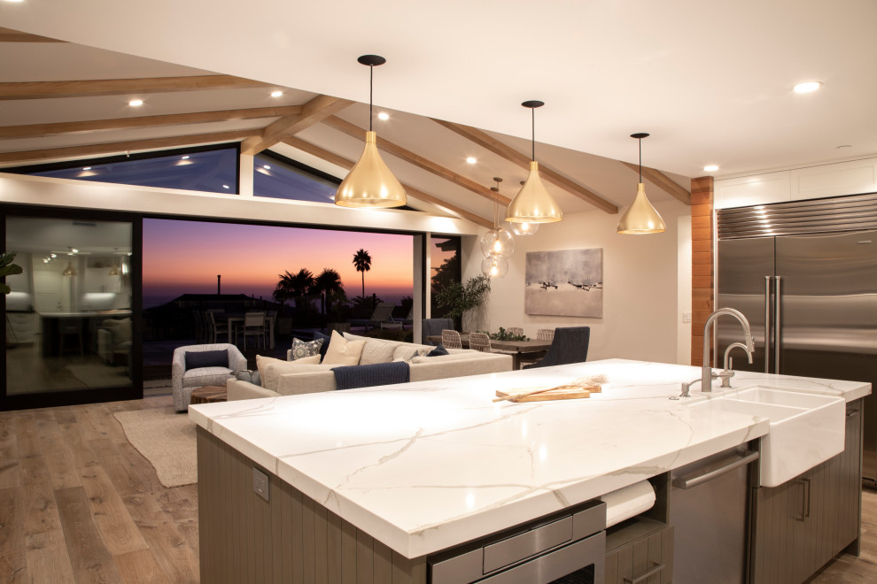 Open concept kitchen - transitional u-shaped open concept kitchen idea in Orange County with a farmhouse sink, raised-panel cabinets, medium tone wood cabinets, quartz countertops, white backsplash, brick backsplash, stainless steel appliances, an island and white countertops
