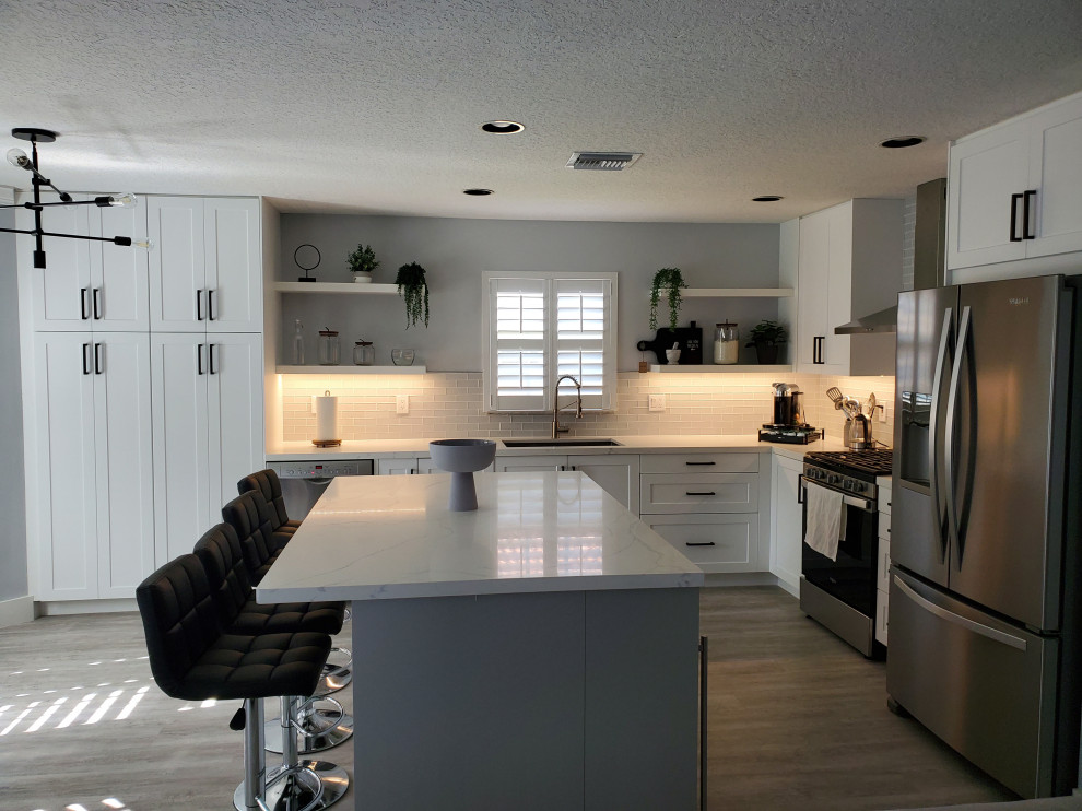 Large transitional l-shaped kitchen pantry in Miami with shaker cabinets, white cabinets, quartz benchtops and with island.