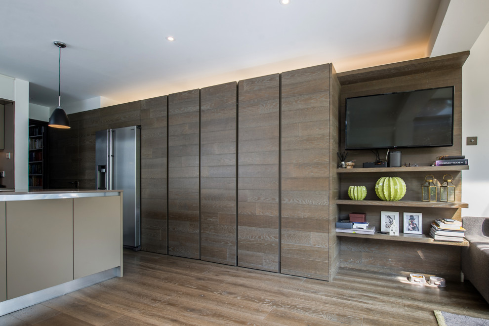 Photo of a modern kitchen in London with flat-panel cabinets, brown cabinets and with island.