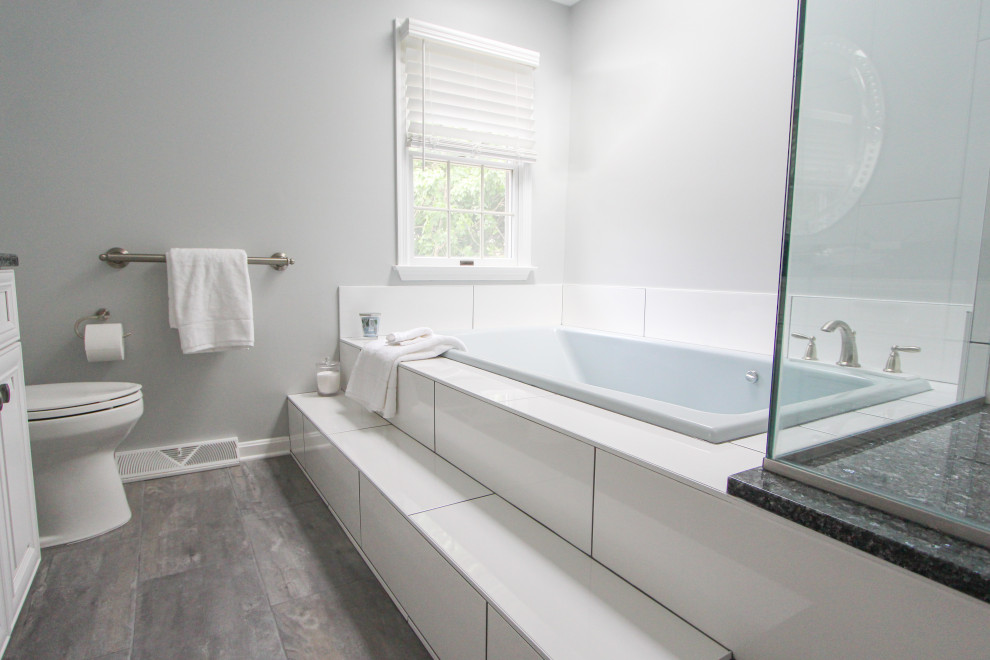 Foto di una stanza da bagno padronale con ante bianche, piastrelle bianche, pareti bianche, pavimento con piastrelle in ceramica, top in granito, pavimento grigio, top nero, panca da doccia e due lavabi
