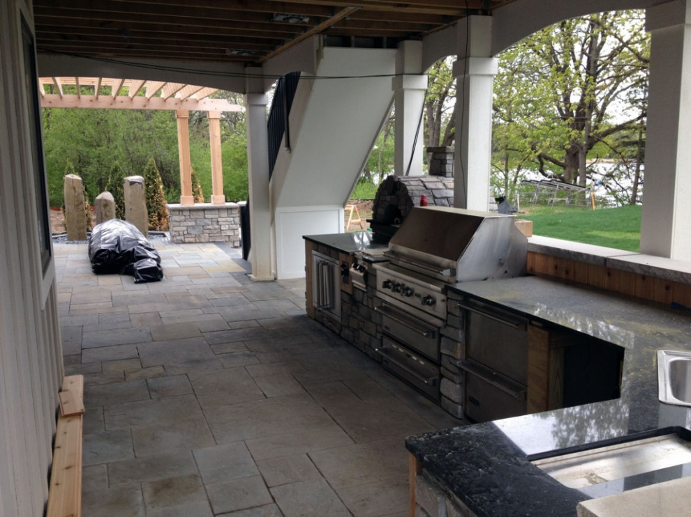 This is an example of a large traditional backyard partial sun garden for summer in Minneapolis with with waterfall and natural stone pavers.