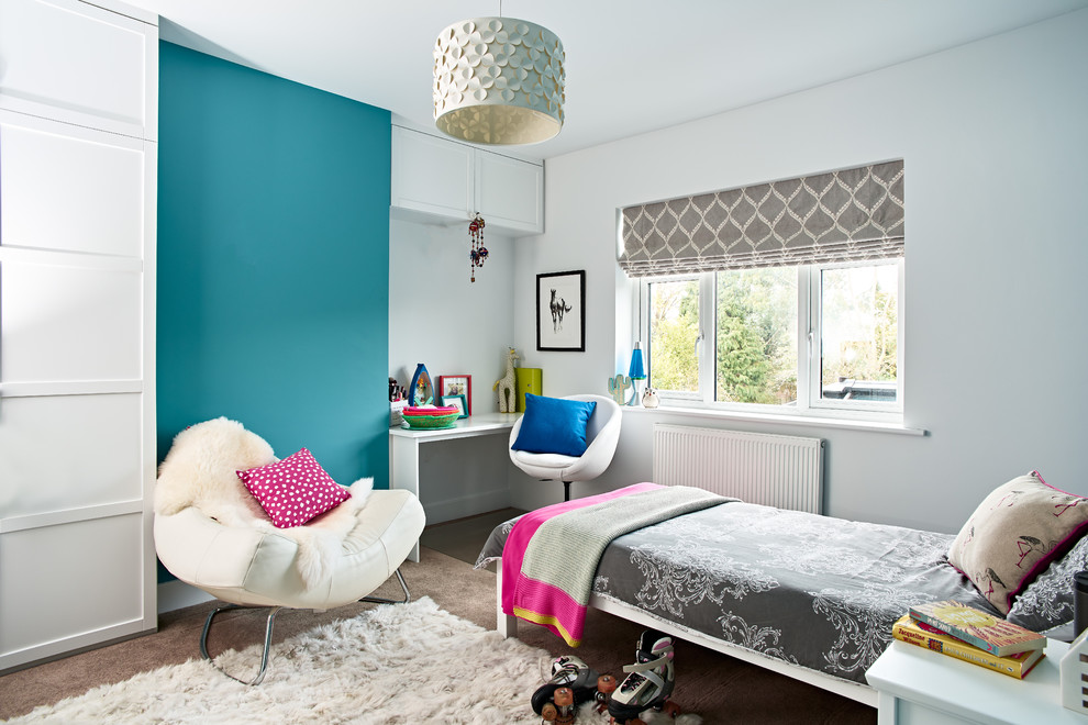 This is an example of a large contemporary kids' room for girls in Berkshire with blue walls, carpet and grey floor.