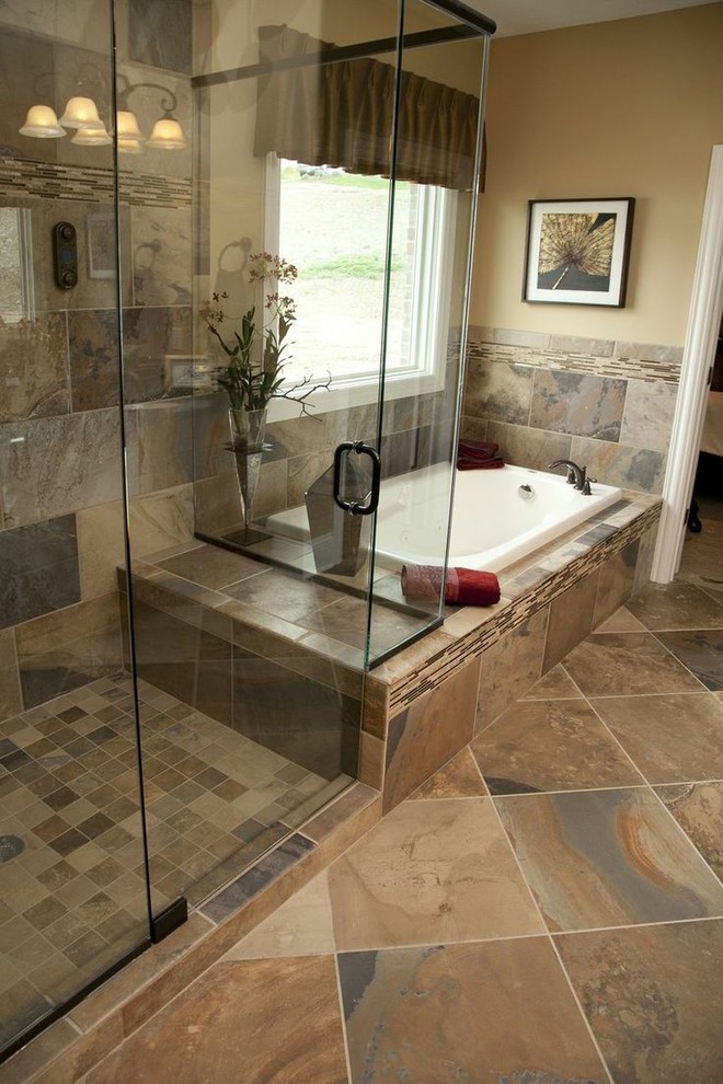 This is an example of a mid-sized traditional master bathroom in Toronto with a corner shower, multi-coloured tile, beige tile, brown tile, gray tile, orange tile, beige walls, a drop-in tub, ceramic tile, ceramic floors, brown floor and a hinged shower door.