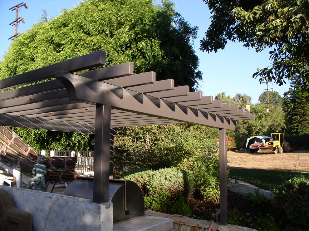 This is an example of a mid-sized transitional partial sun backyard stone landscaping in Orange County.