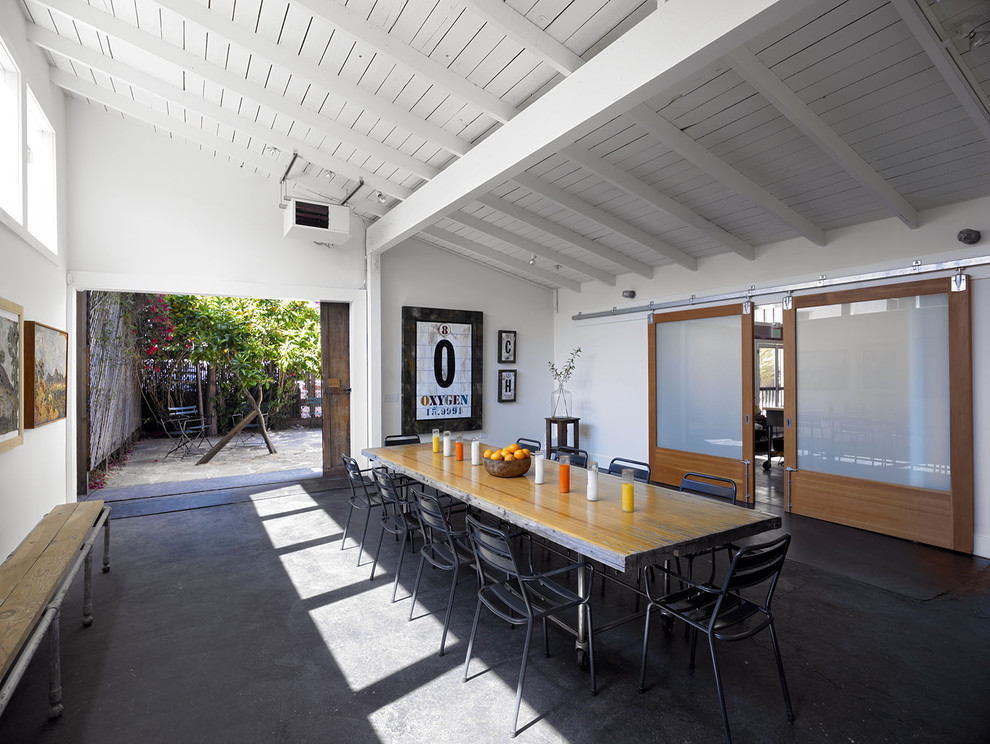 This is an example of an industrial dining room in San Francisco with concrete floors.