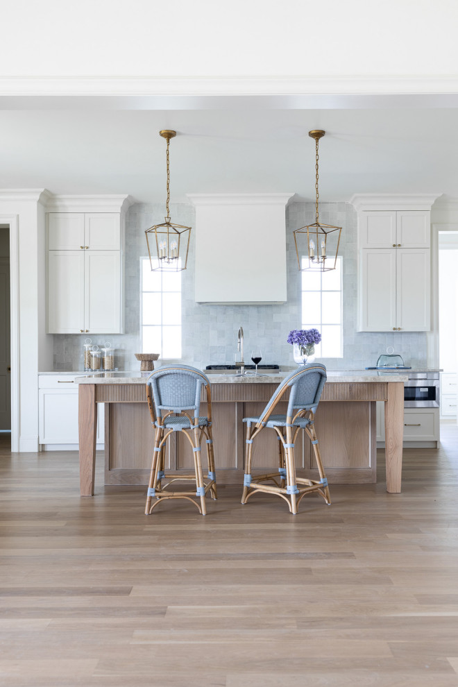 Inspiration for a huge transitional light wood floor kitchen remodel in Dallas with shaker cabinets, white cabinets, quartzite countertops, stainless steel appliances, an island and beige countertops