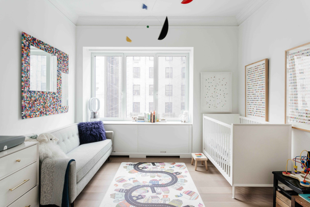 This is an example of a mid-sized contemporary nursery in New York with grey walls, light hardwood floors and beige floor.