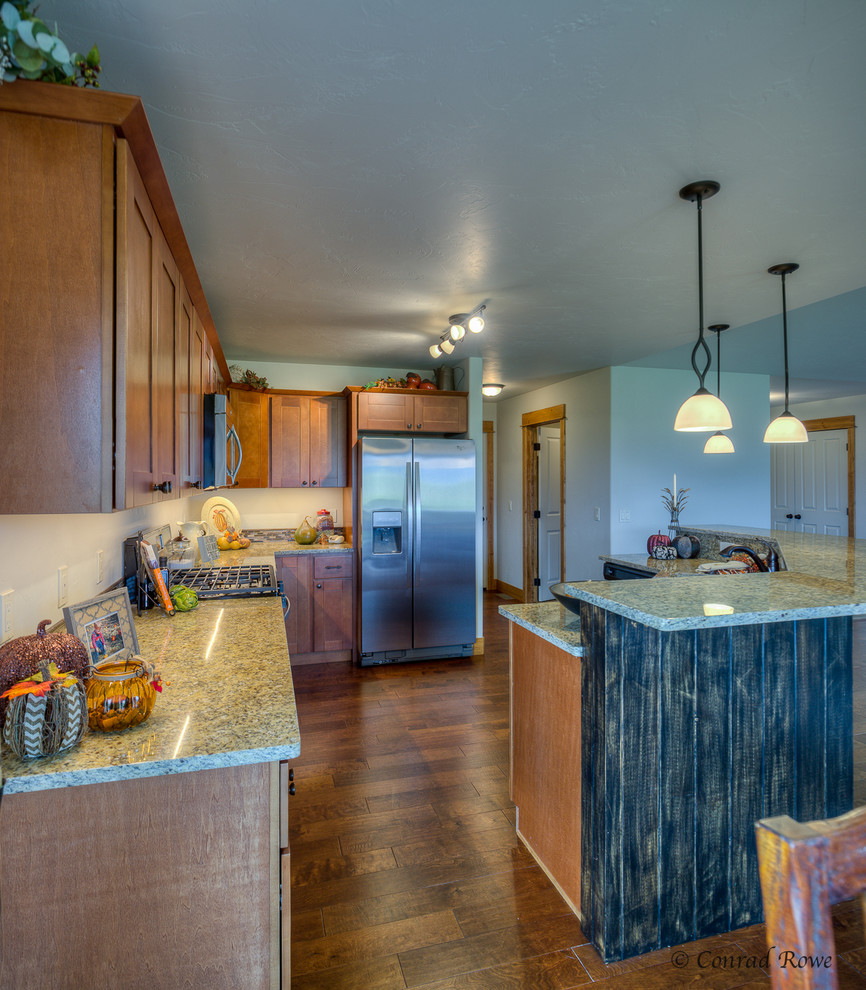 Mid-sized mountain style u-shaped medium tone wood floor eat-in kitchen photo with a double-bowl sink, recessed-panel cabinets, medium tone wood cabinets, granite countertops, multicolored backsplash, mosaic tile backsplash, stainless steel appliances and an island