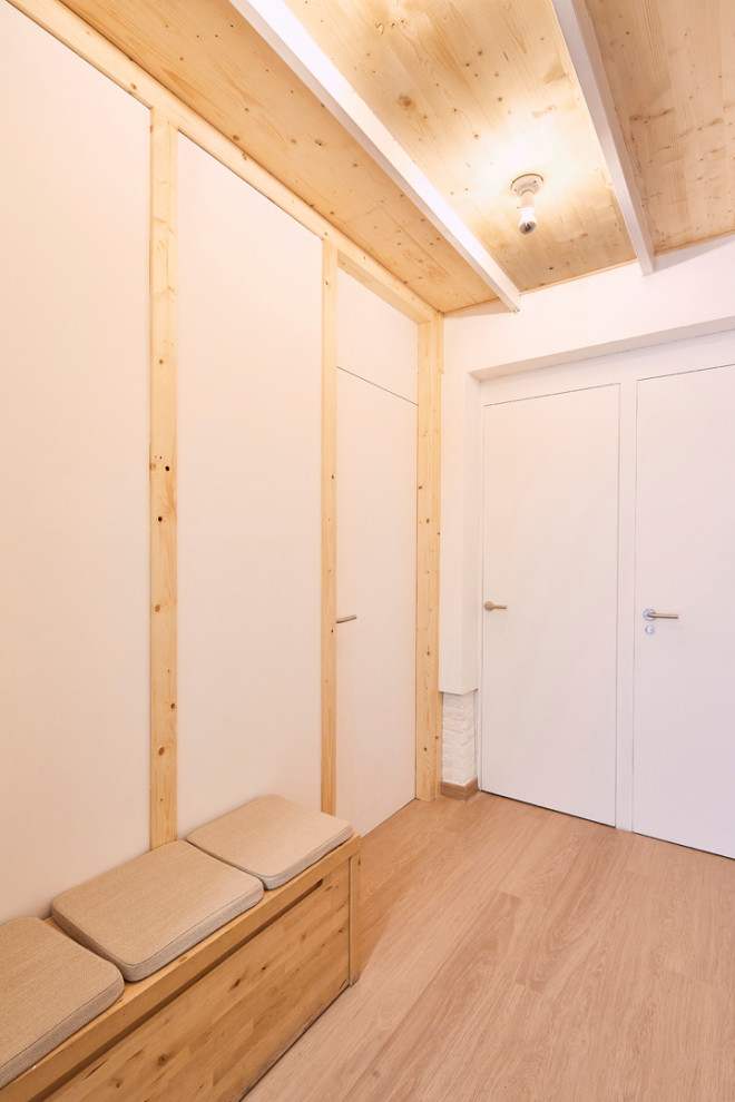 Aménagement d'un petit hall d'entrée scandinave en bois avec un mur blanc, parquet clair, une porte simple, une porte en bois clair, un sol beige et un plafond voûté.