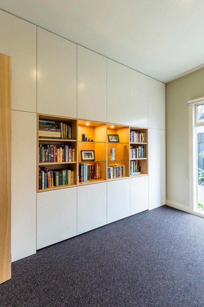 This is an example of a mid-sized contemporary study room in Melbourne with beige walls, carpet, no fireplace, a built-in desk and grey floor.