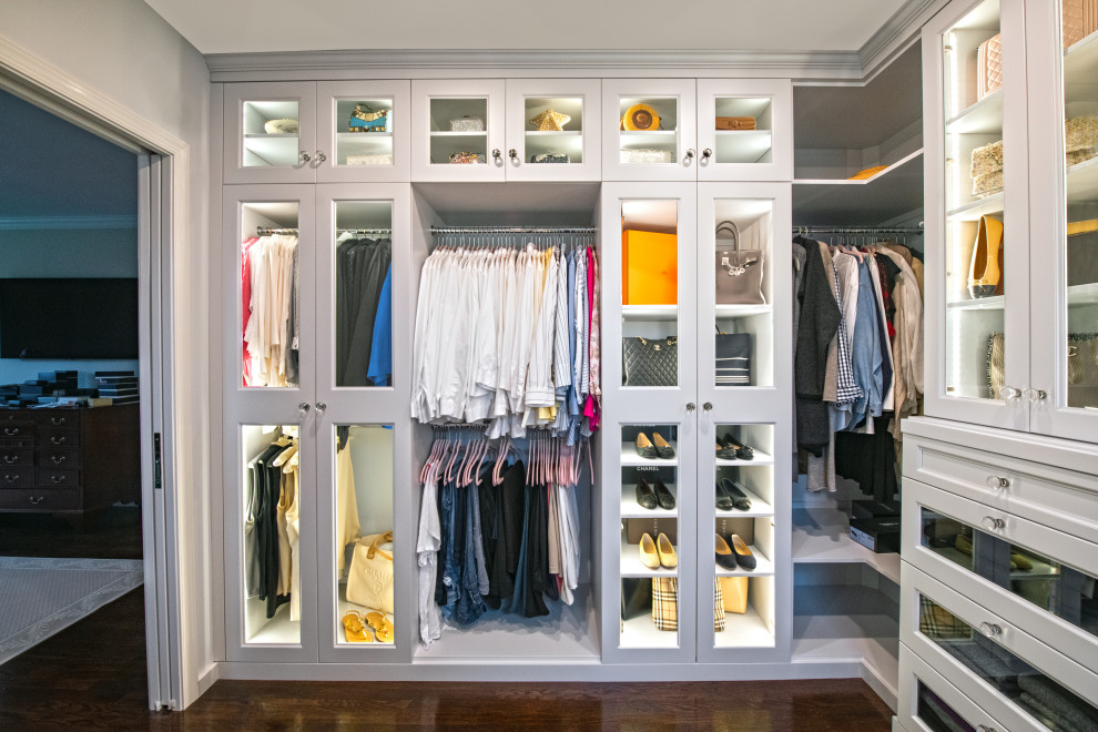 This is an example of a mid-sized traditional women's dressing room in Philadelphia with shaker cabinets, white cabinets, dark hardwood floors and brown floor.