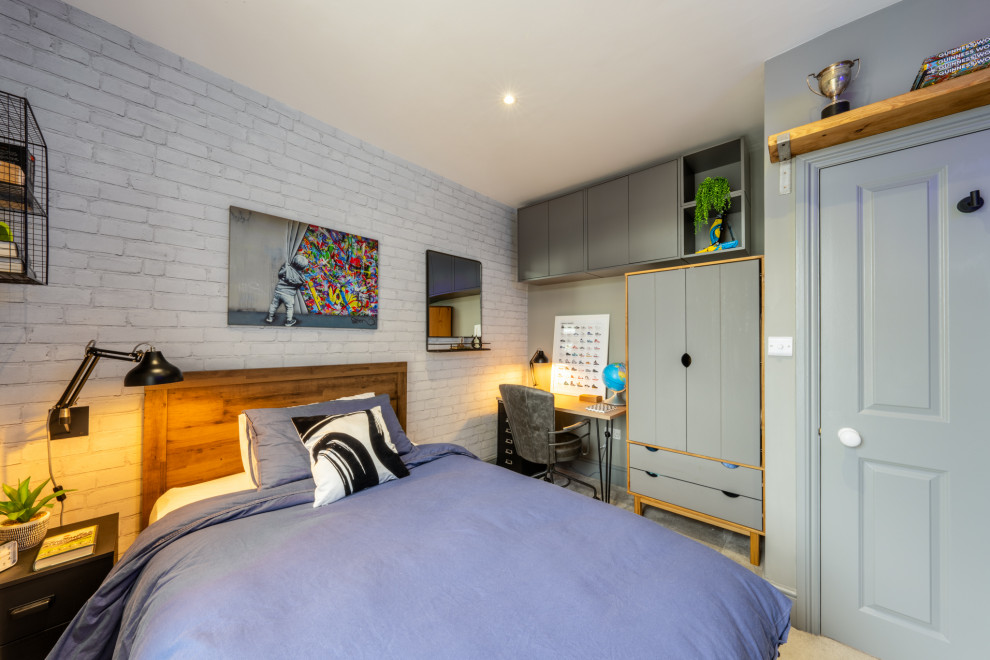 Industriell inredning av ett litet barnrum kombinerat med sovrum, med grå väggar, heltäckningsmatta och grått golv