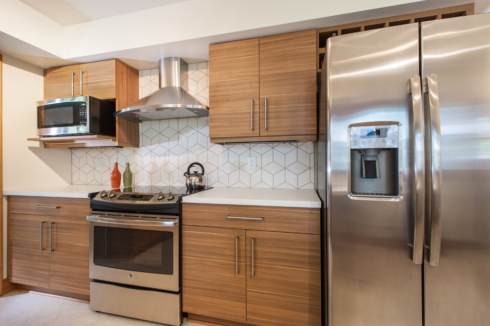 This is an example of a mid-sized contemporary u-shaped eat-in kitchen in Minneapolis with flat-panel cabinets, medium wood cabinets, solid surface benchtops, white splashback, ceramic splashback, stainless steel appliances, vinyl floors and a peninsula.