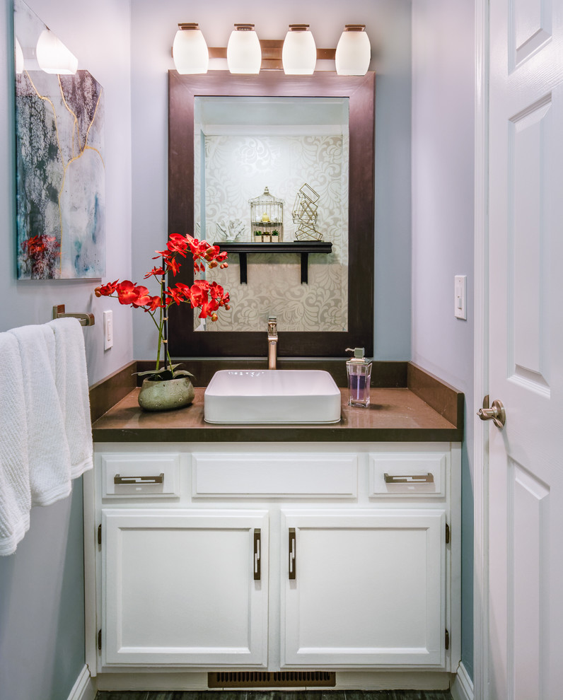 Photo of a small transitional powder room in San Francisco with shaker cabinets, white cabinets, a two-piece toilet, gray tile, grey walls, porcelain floors, a vessel sink, engineered quartz benchtops and grey floor.