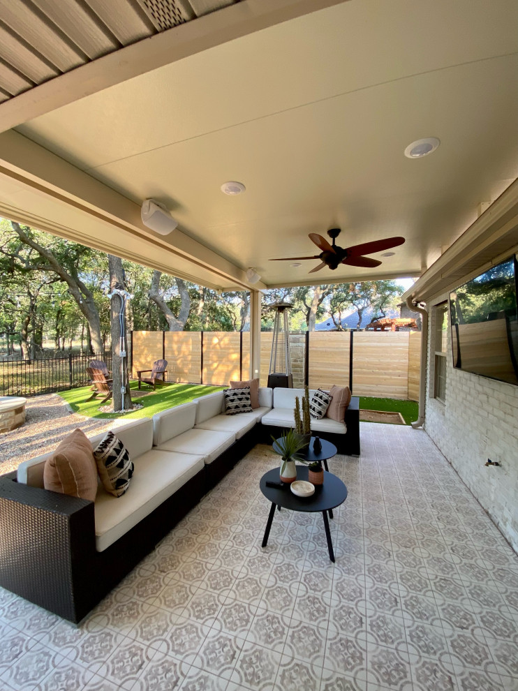 Immagine di un patio o portico minimal dietro casa con piastrelle e un parasole
