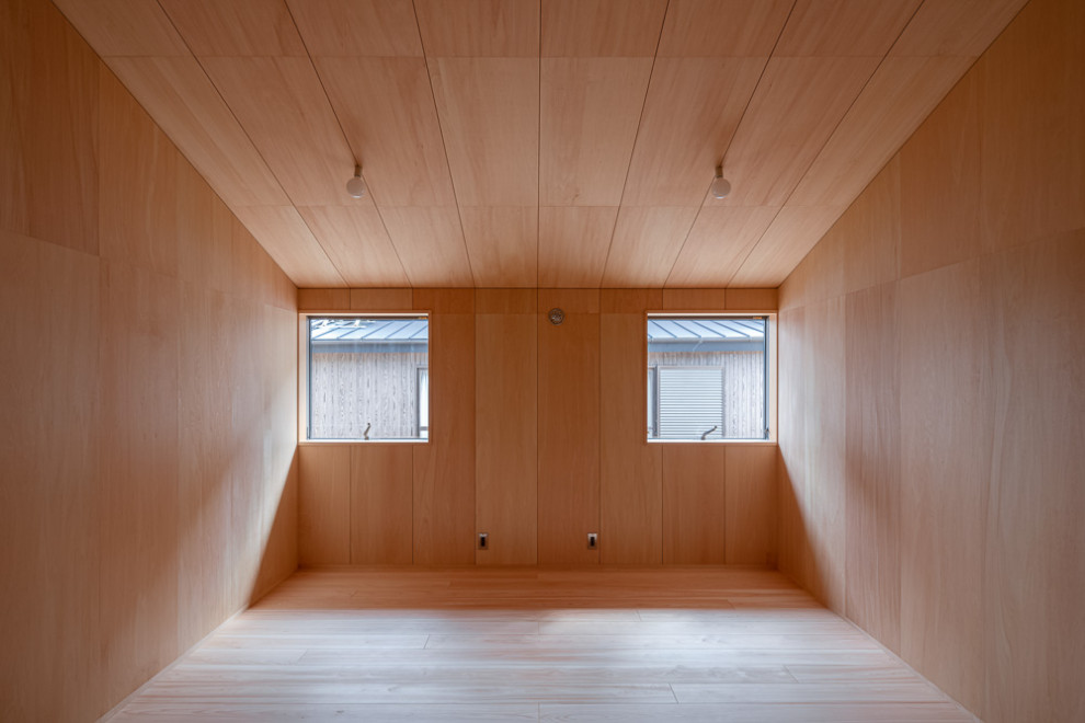 Photo of a mid-sized modern gender-neutral kids' study room for kids 4-10 years old in Other with beige walls, light hardwood floors, beige floor, timber and planked wall panelling.