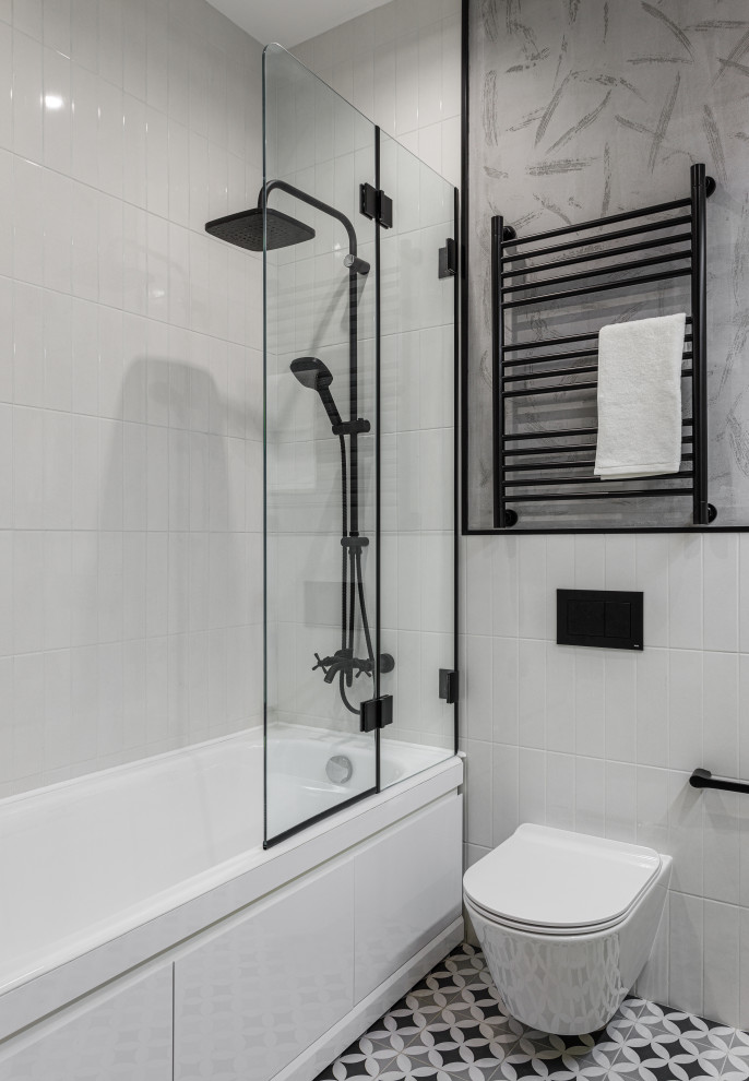 Inspiration for a small contemporary ensuite bathroom in Moscow with flat-panel cabinets, yellow cabinets, an alcove bath, a wall mounted toilet, white tiles, ceramic tiles, grey walls, porcelain flooring, a trough sink, solid surface worktops, black floors, white worktops, a wall niche, double sinks and a built in vanity unit.